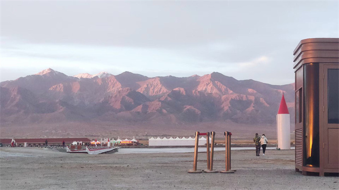 中途歇脚处,远处为戈壁和高山,夕阳映射下,延绵不绝的高山呈火红的独特风貌,甚是绝美！